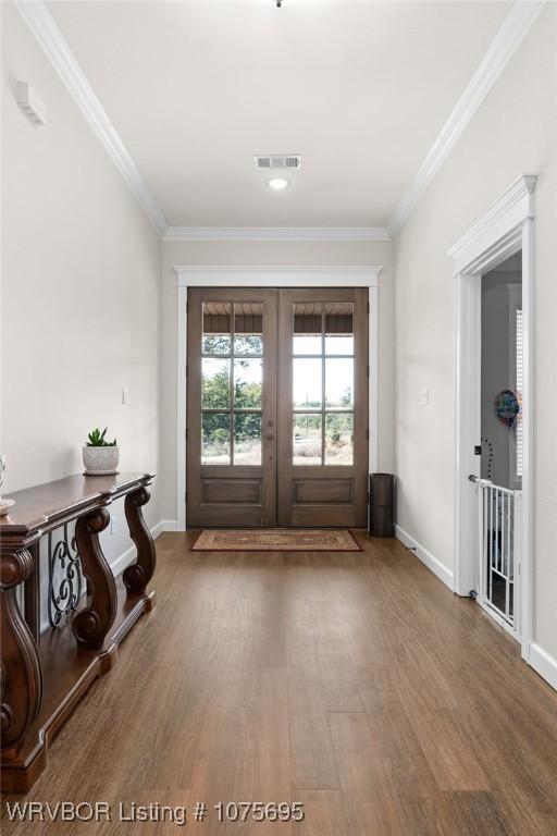 doorway to outside featuring hardwood / wood-style floors, crown molding, and french doors