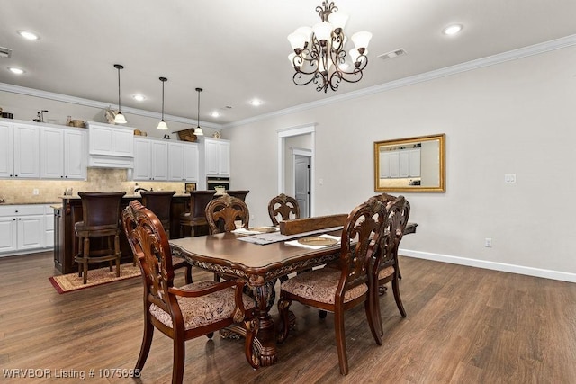 dining space featuring crown molding, dark wood-type flooring, and an inviting chandelier