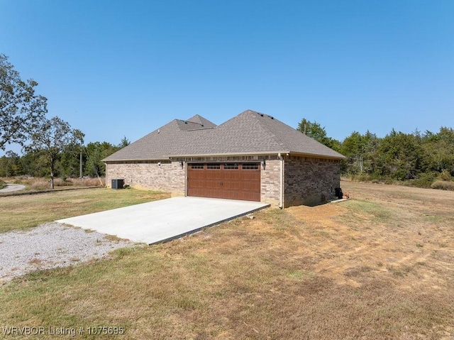 view of side of home with a lawn and a garage