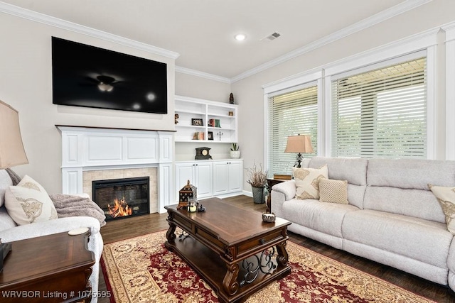 living room with dark hardwood / wood-style floors, ornamental molding, and a fireplace