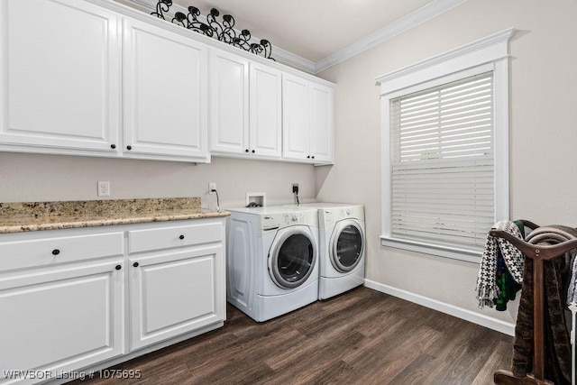 laundry room featuring dark wood-type flooring, crown molding, washer and clothes dryer, and cabinets