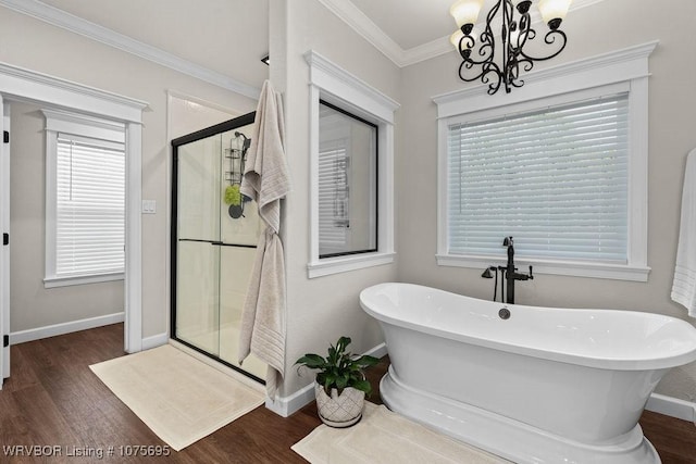 bathroom with hardwood / wood-style floors, a notable chandelier, shower with separate bathtub, and crown molding