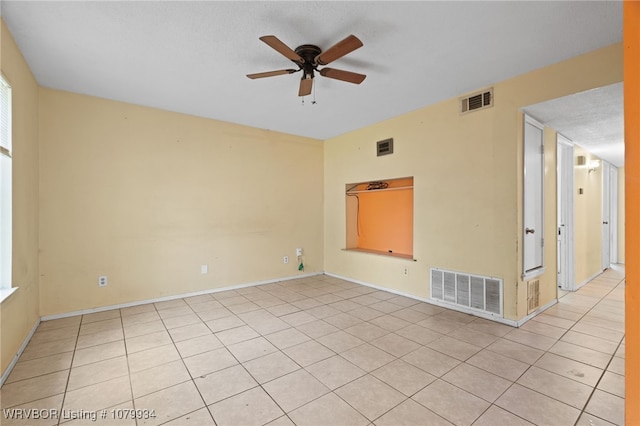 empty room with baseboards, visible vents, and a ceiling fan