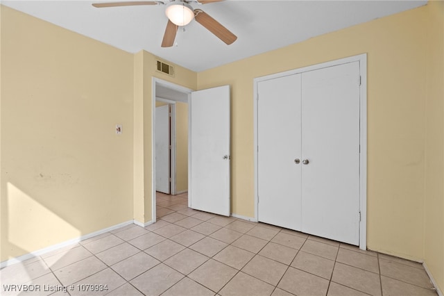 unfurnished bedroom featuring light tile patterned flooring, visible vents, and a closet