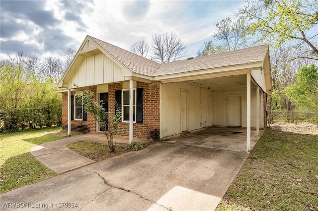 view of property exterior featuring a lawn, a carport, brick siding, and concrete driveway