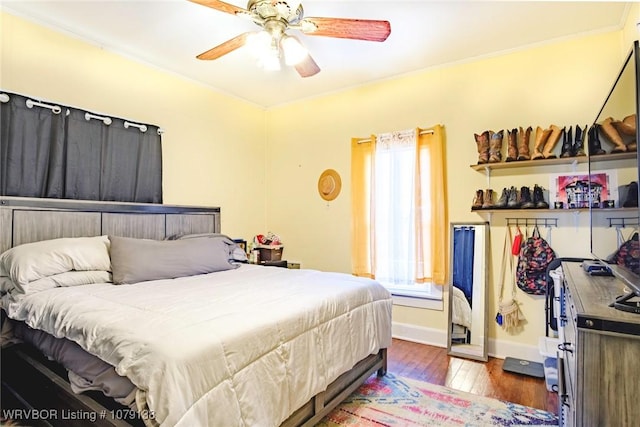 bedroom featuring a ceiling fan, baseboards, and wood finished floors