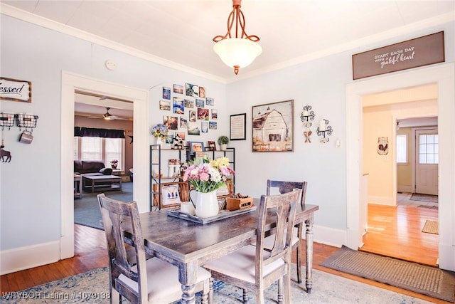 dining space with ornamental molding, a wealth of natural light, and wood finished floors