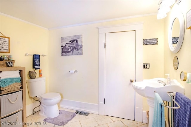 bathroom featuring toilet, tile patterned flooring, baseboards, and crown molding