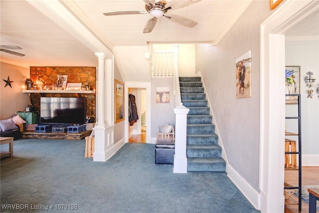 interior space featuring baseboards, carpet flooring, a ceiling fan, and ornate columns