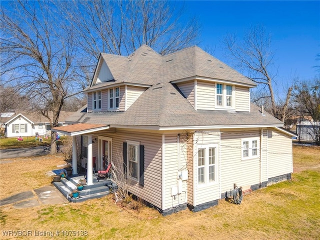 view of property exterior with roof with shingles and a yard