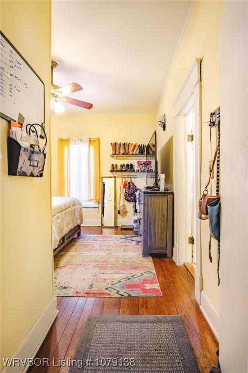 bedroom with a ceiling fan, baseboards, and wood finished floors