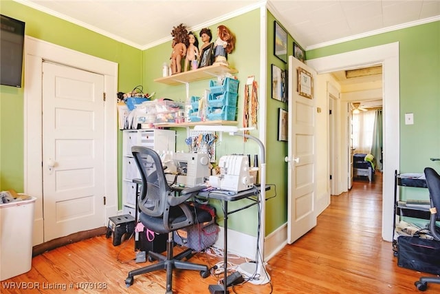 office area featuring baseboards, ornamental molding, and wood finished floors