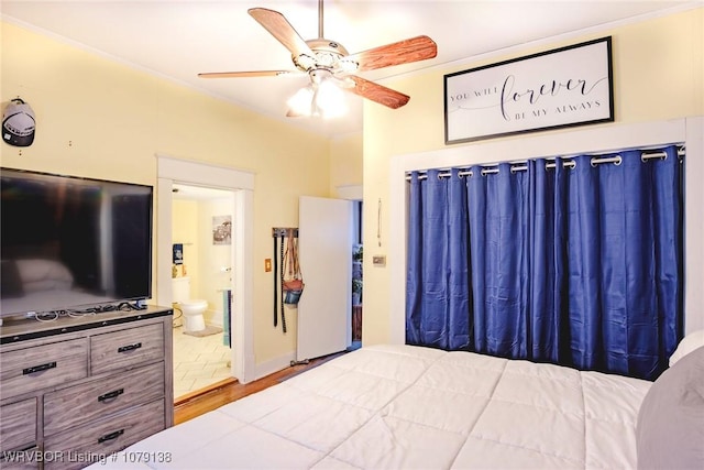 bedroom featuring crown molding, ceiling fan, ensuite bath, and wood finished floors