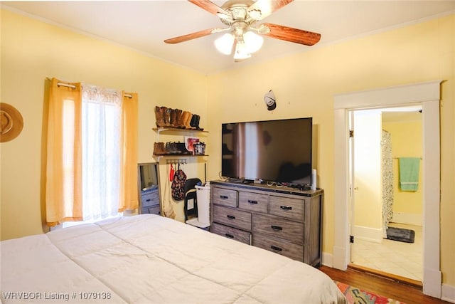 bedroom with baseboards, a ceiling fan, wood finished floors, and ornamental molding