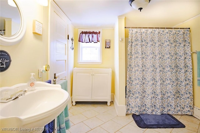 bathroom with a stall shower, tile patterned flooring, and a sink