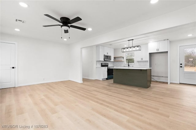 48 W Gary St, Greenwood, AR 72936 - kitchen featuring stainless steel appliances, a kitchen island, light hardwood / wood-style floors, pendant lighting, and white cabinets