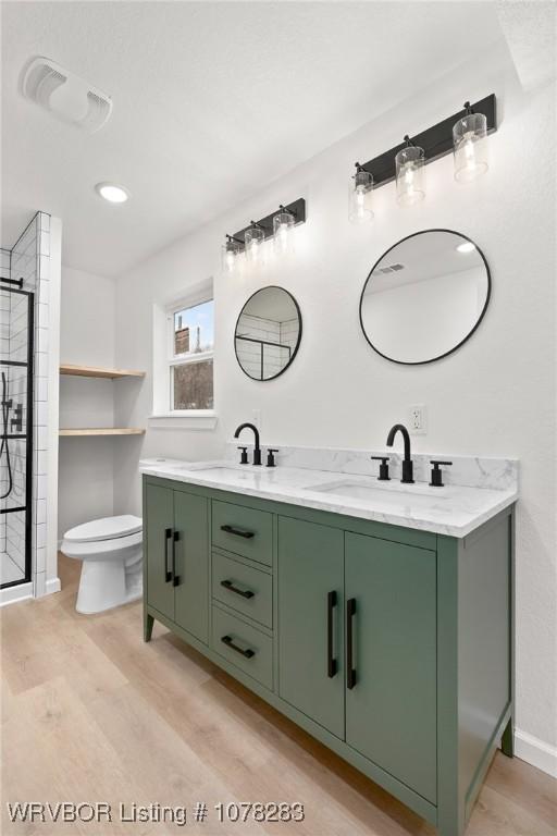 48 W Gary St, Greenwood, AR 72936 - bathroom featuring hardwood / wood-style floors, vanity, toilet, and an enclosed shower