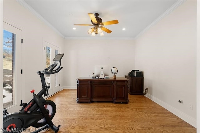 exercise room with baseboards, light wood-style flooring, a wealth of natural light, and crown molding