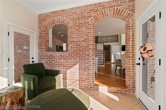 interior space with stairway, ornamental molding, arched walkways, and light tile patterned flooring