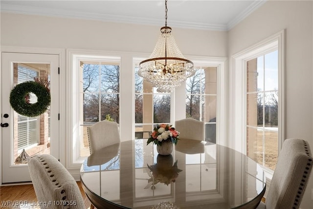 dining space featuring a chandelier, wood finished floors, and crown molding