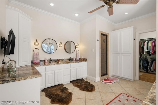 bathroom featuring a stall shower, tile patterned floors, a walk in closet, crown molding, and vanity