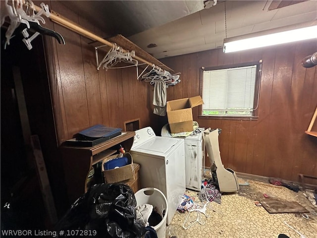 clothes washing area featuring washer and dryer and wooden walls