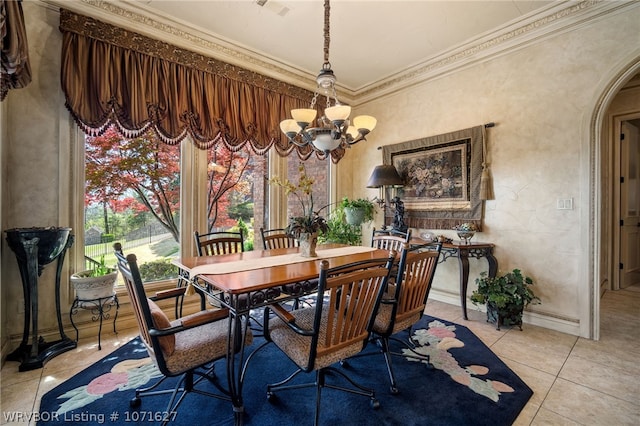 dining area with light tile patterned flooring, crown molding, and an inviting chandelier