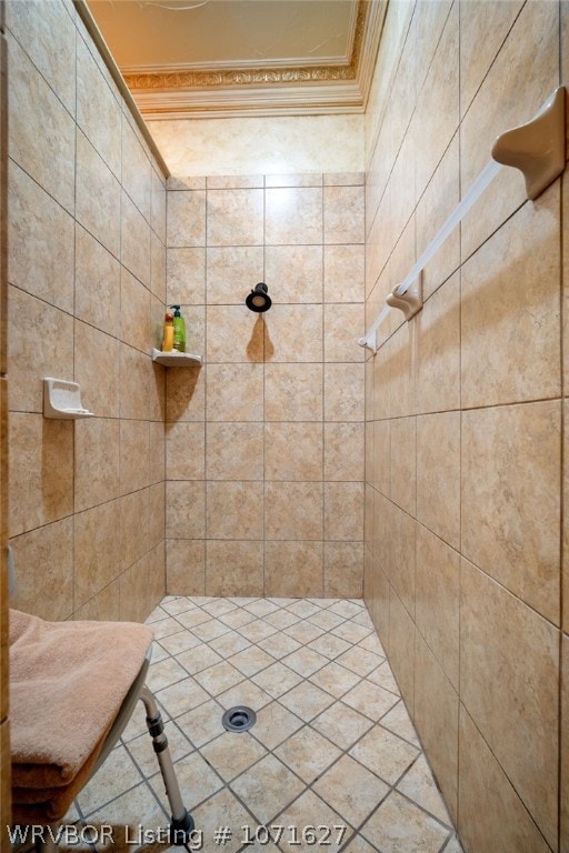 bathroom with ornamental molding and tiled shower