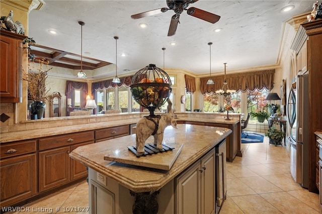 kitchen featuring ornamental molding, a kitchen island, plenty of natural light, and coffered ceiling