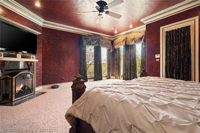 carpeted bedroom with a tile fireplace, ceiling fan, and crown molding