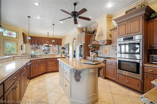 kitchen featuring a center island, stainless steel appliances, light stone counters, pendant lighting, and ornamental molding