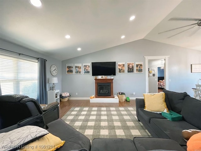 527 Polk Road 59, Mena, AR 71953 - living room featuring vaulted ceiling, wood finished floors, a glass covered fireplace, ceiling fan, and baseboards