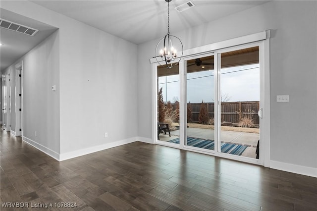 empty room with an inviting chandelier and dark hardwood / wood-style flooring