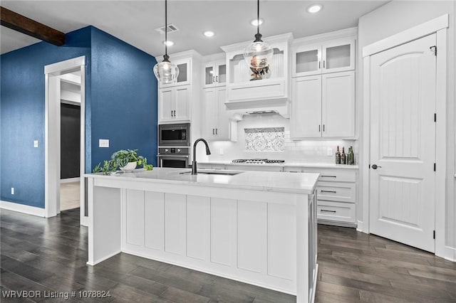 kitchen featuring pendant lighting, sink, stainless steel appliances, and a center island with sink