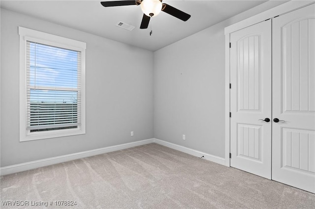 unfurnished bedroom featuring light colored carpet and ceiling fan