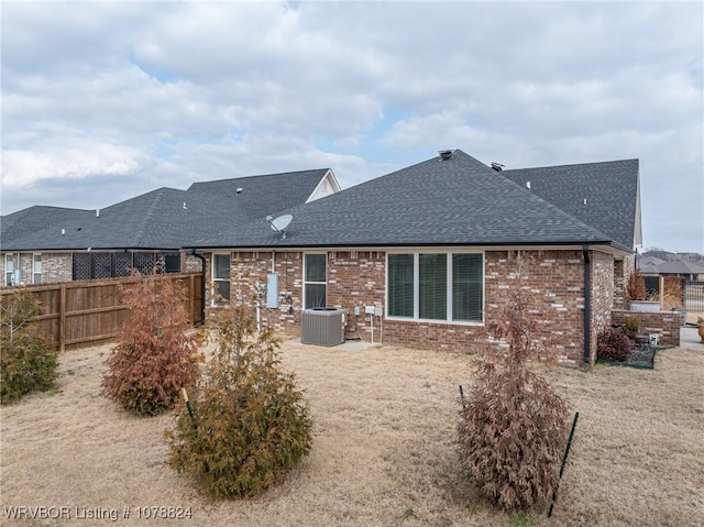 rear view of property featuring a patio, central AC, and a lawn