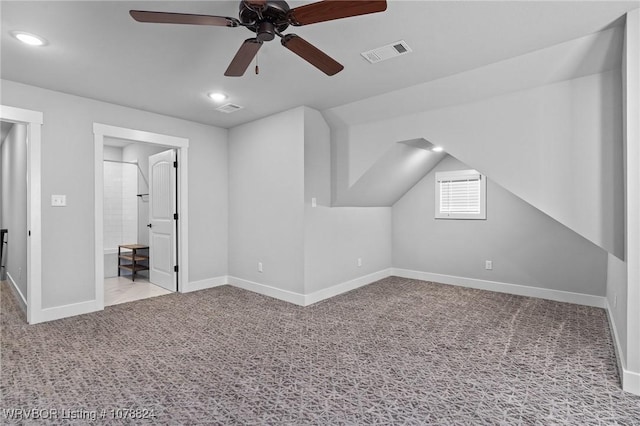 bonus room with lofted ceiling and light carpet