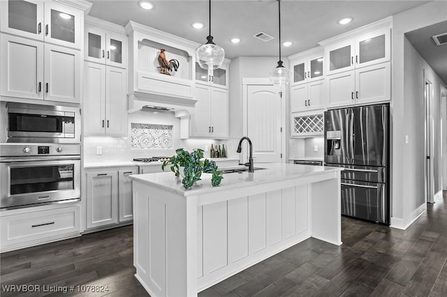 kitchen featuring stainless steel appliances, sink, white cabinets, and decorative light fixtures