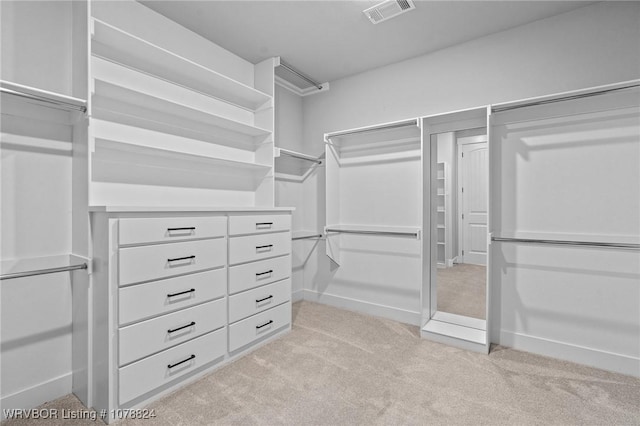 walk in closet featuring light carpet