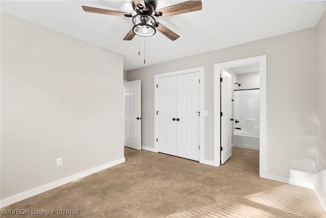 unfurnished bedroom with light carpet, a closet, ensuite bath, and ceiling fan