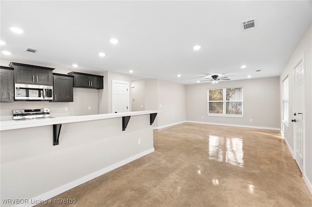 kitchen featuring a kitchen bar, appliances with stainless steel finishes, and ceiling fan