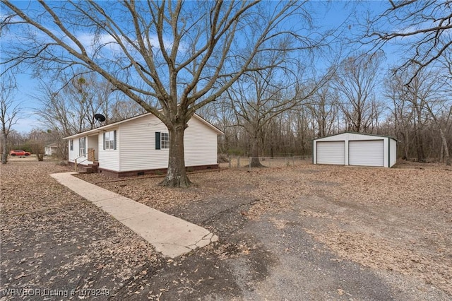 view of side of property with crawl space, a detached garage, and an outdoor structure