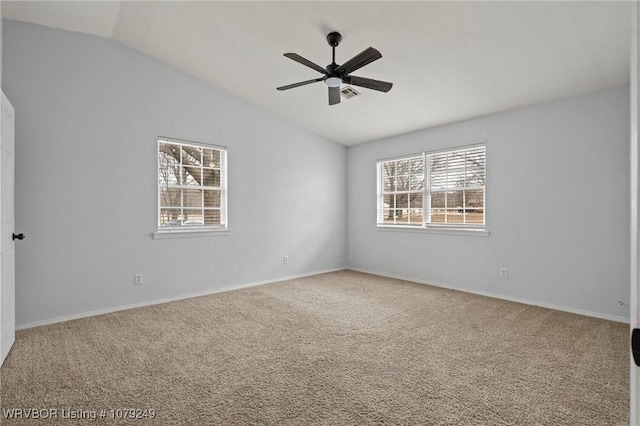 empty room featuring carpet, visible vents, vaulted ceiling, and ceiling fan