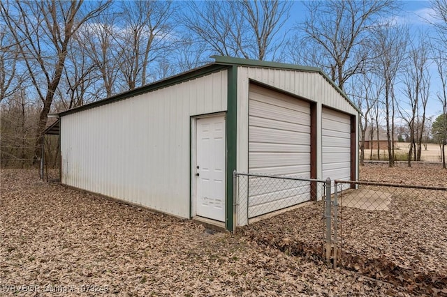 view of outdoor structure with fence and an outbuilding