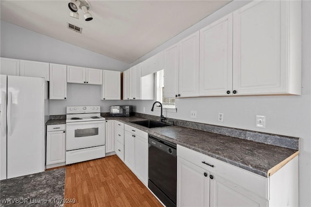 kitchen with dark countertops, white appliances, white cabinets, and a sink