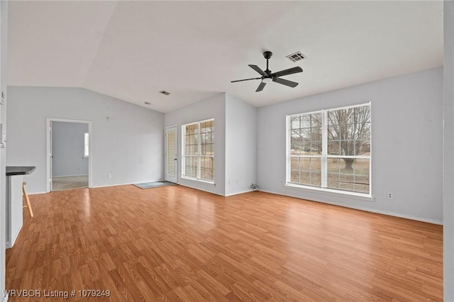 unfurnished living room with lofted ceiling, light wood-style flooring, visible vents, and ceiling fan