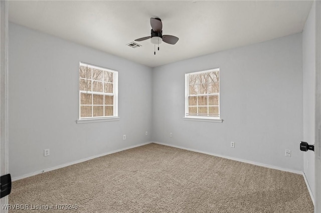 unfurnished room with a ceiling fan, carpet, a healthy amount of sunlight, and visible vents