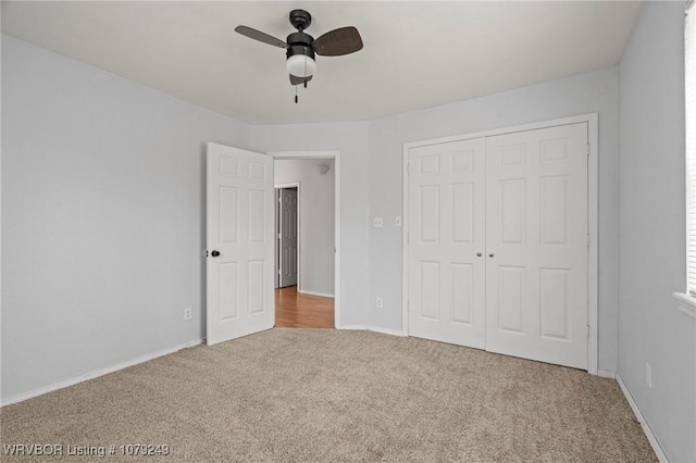 unfurnished bedroom with carpet floors, a ceiling fan, baseboards, and a closet