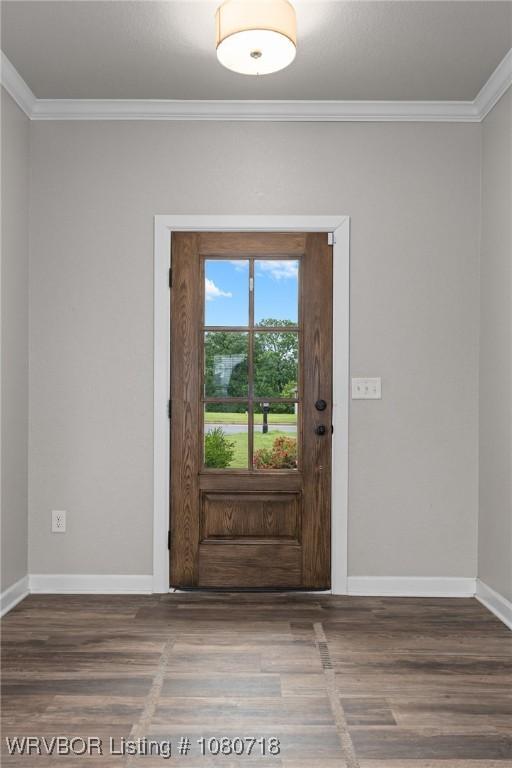 doorway to outside featuring baseboards, crown molding, and wood finished floors