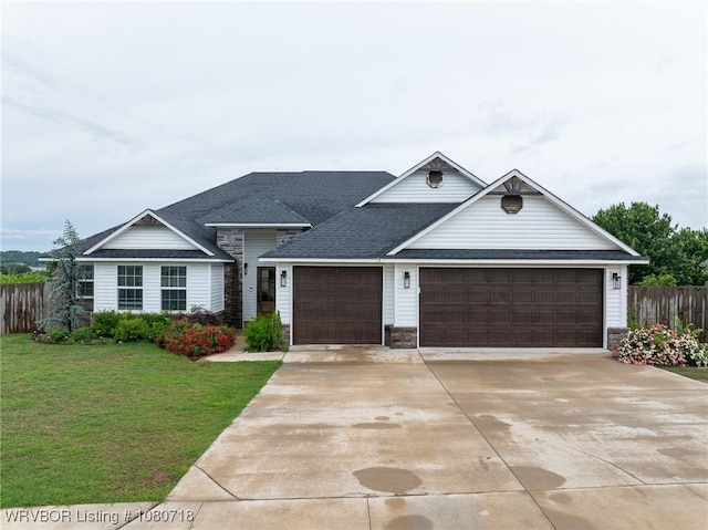 ranch-style house featuring fence, an attached garage, concrete driveway, a front lawn, and a shingled roof